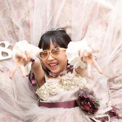 ピンクのドレスの上でピースしてる女の子